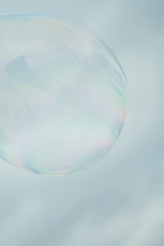 a blue - green background, showing an oval bubble floating up into the sky