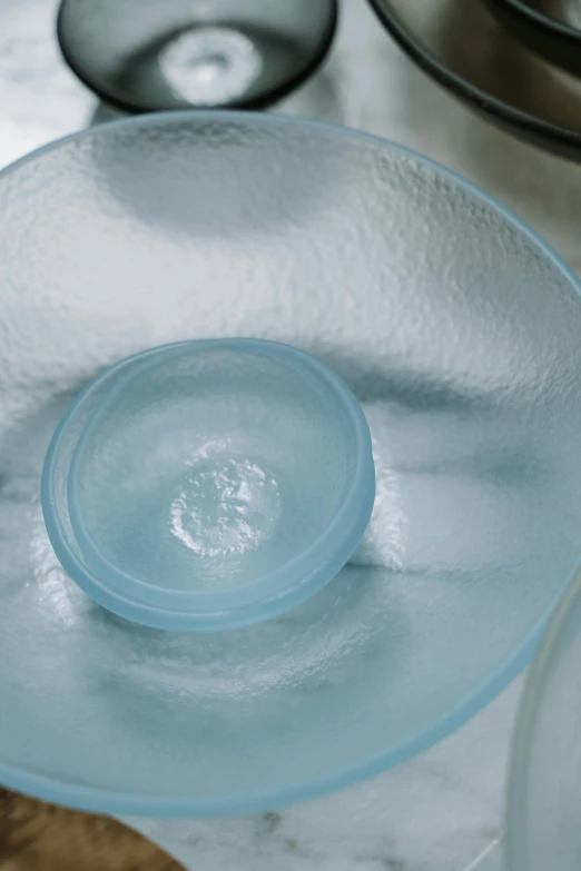 three different glass plates on a table, one with a circle