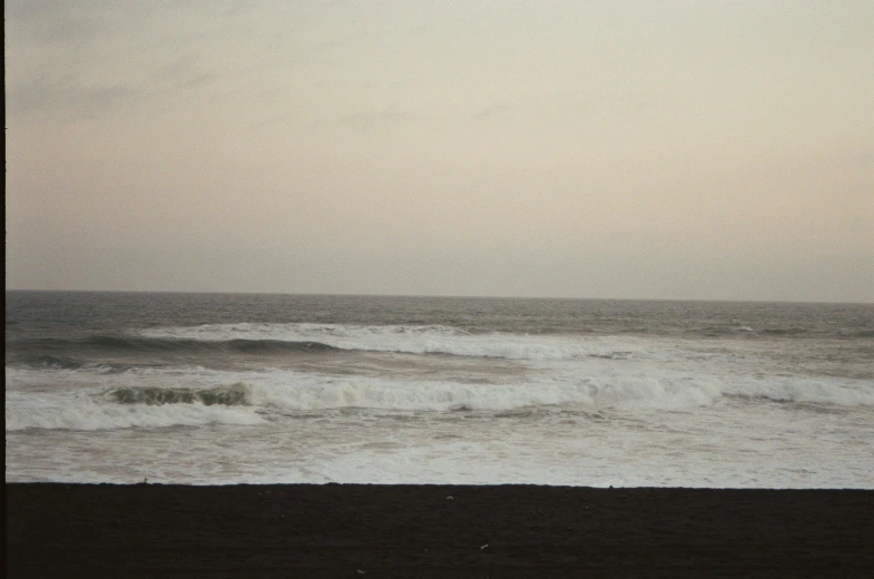 a person walking along the beach near the water