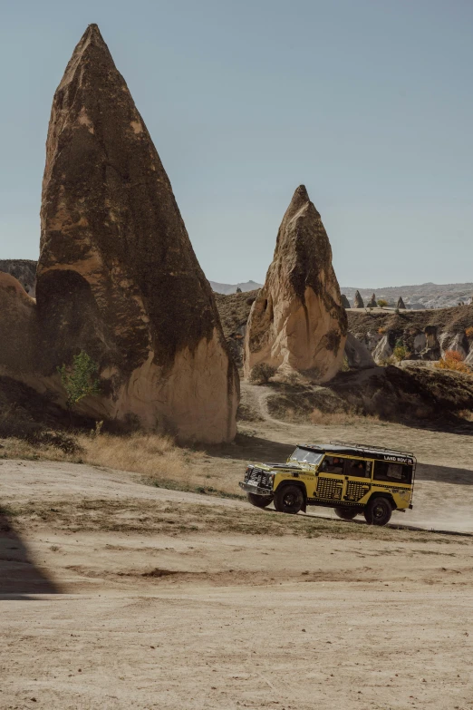 a yellow vehicle parked next to a large brown mountain