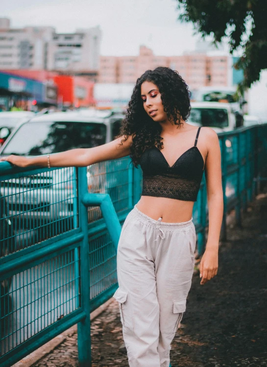 a person leaning against a fence near a car