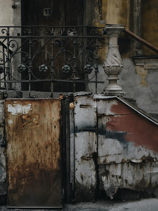 dirty metal doors in front of an iron fence