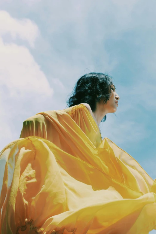 a girl in a yellow sarong against the blue sky