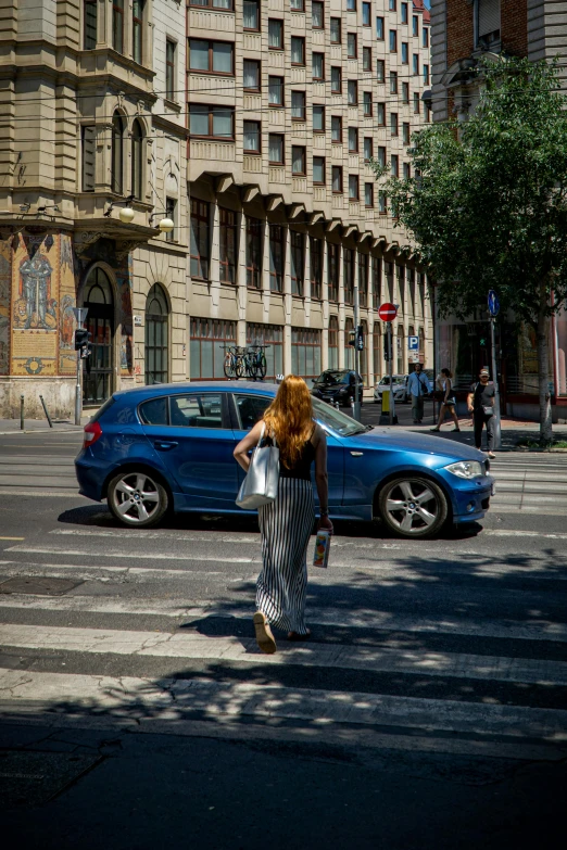 a person walks across the street in front of an apartment building