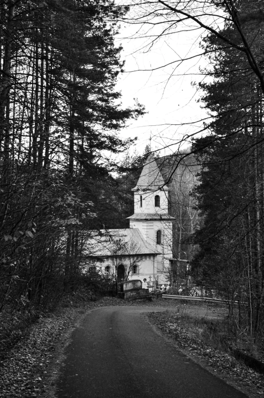 black and white pograph of an old house on the road