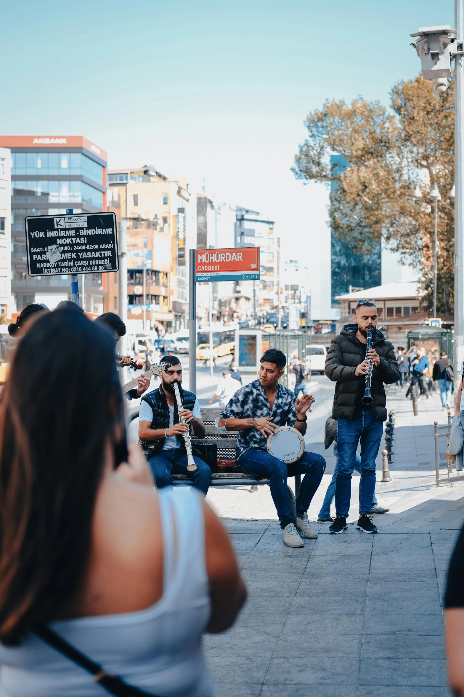 a group of people sitting around on top of the sidewalk