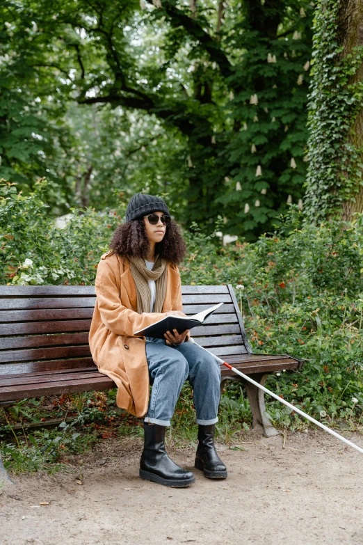 woman sitting on a park bench using a notebook