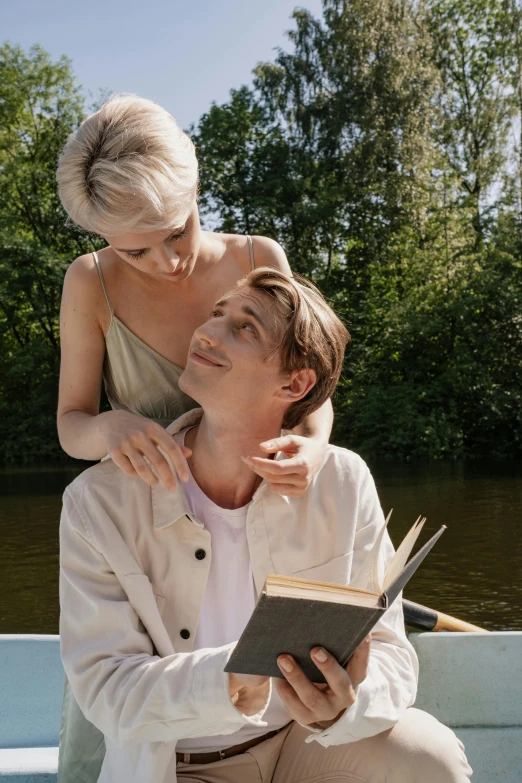 a young woman is holding a young woman as she reads a book