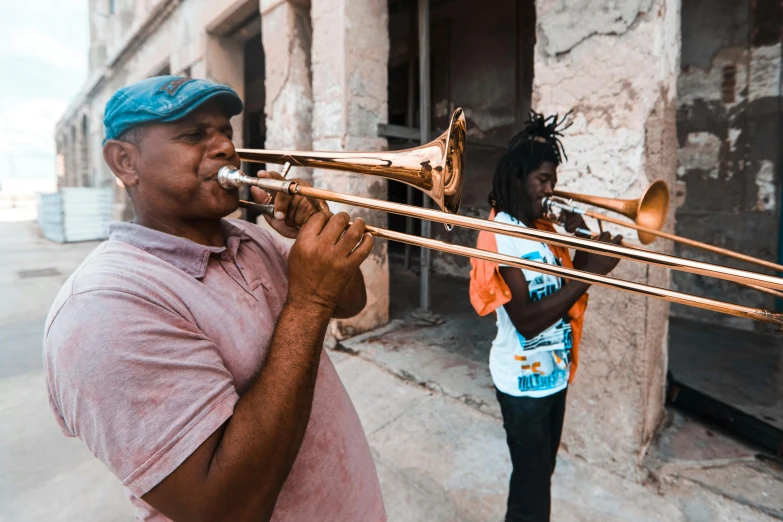 two men playing trumpets in front of an old building