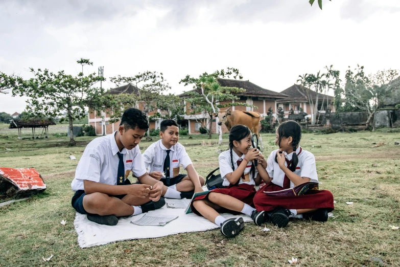 a group of boys sitting on top of a blanket