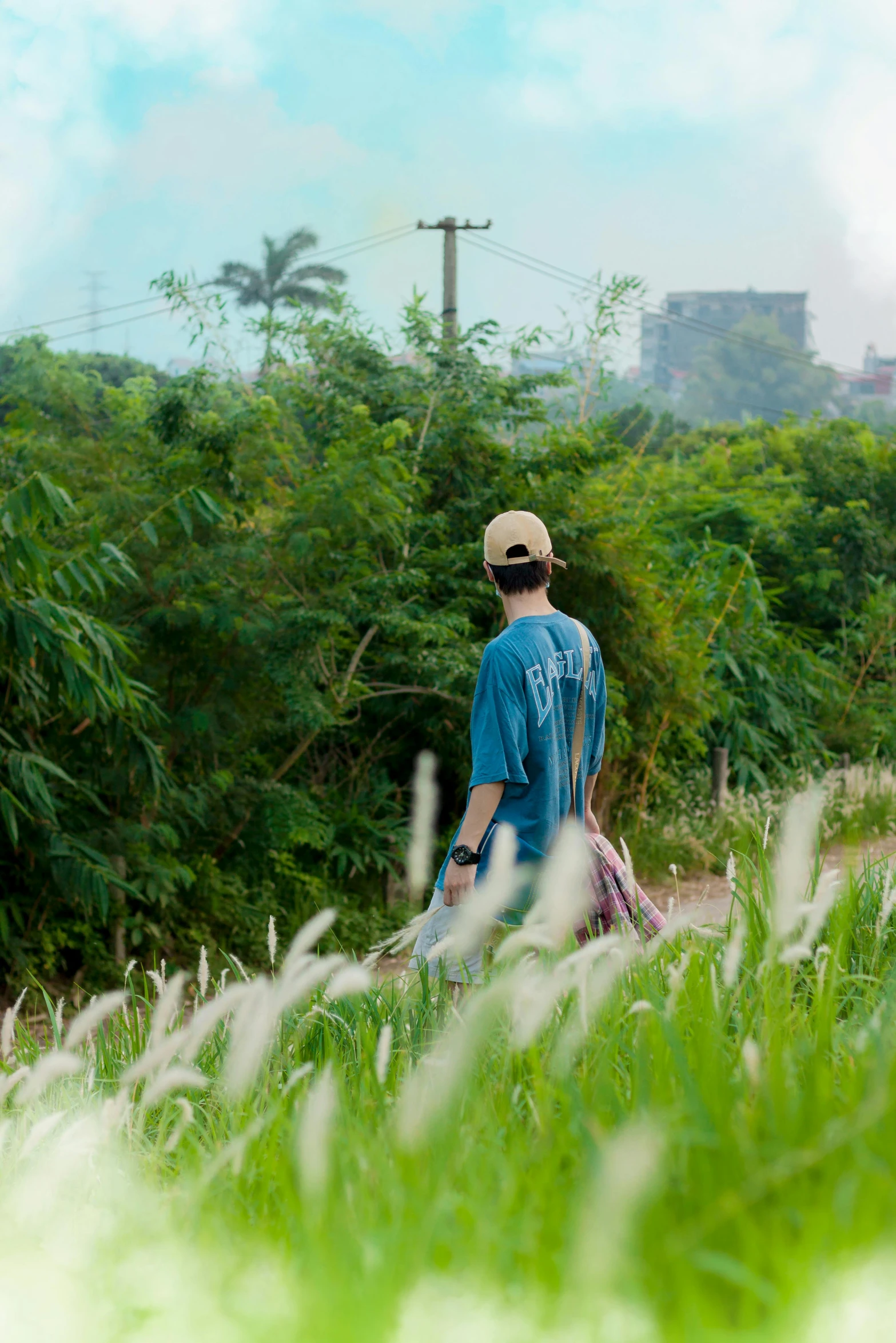 a man with a straw hat standing on the edge of a path