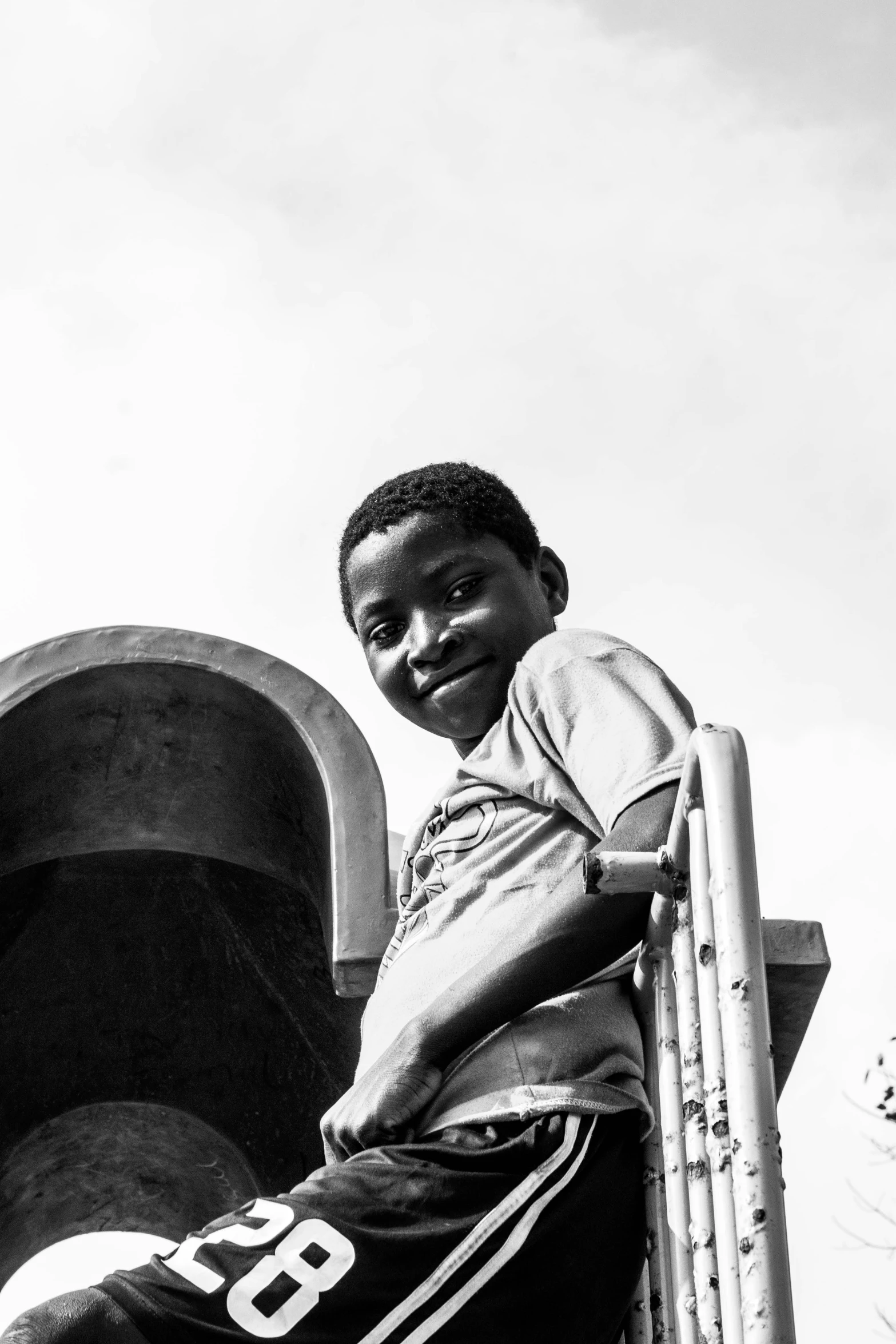 an african american boy sitting on a wall