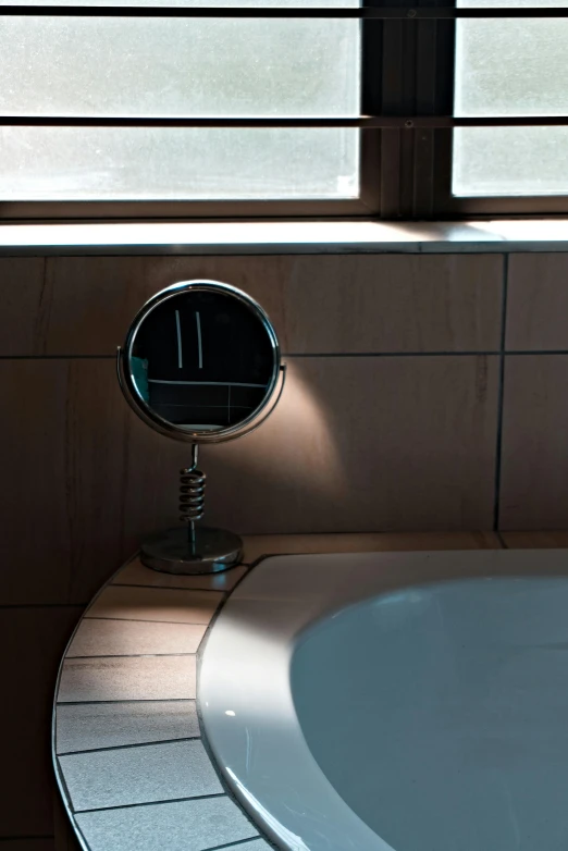 a mirror sitting in front of a window next to a sink