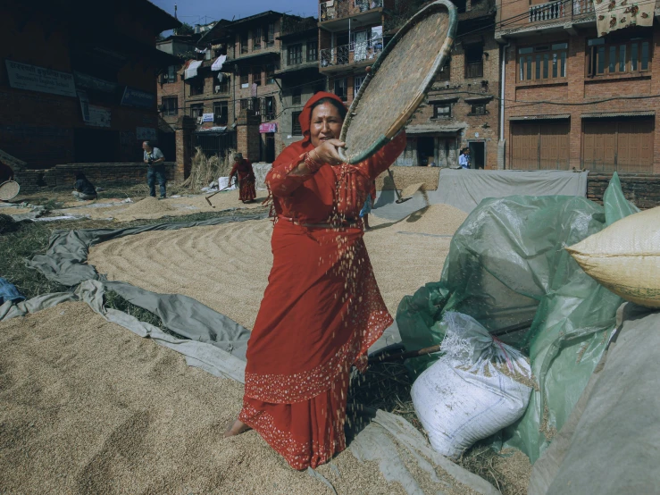 a woman in red dress holding up a large frying pan