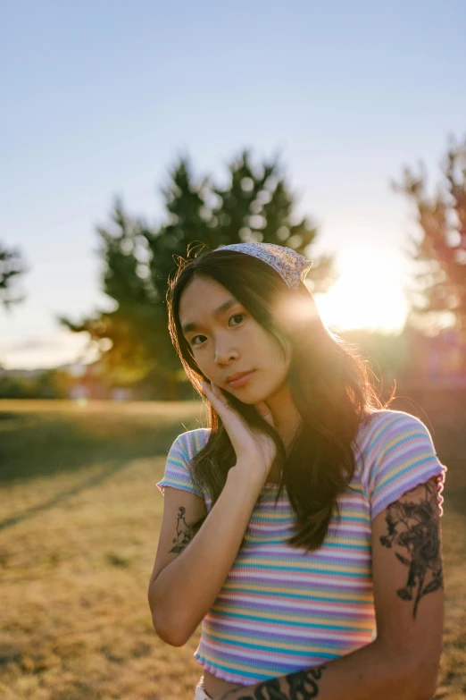 a girl poses for the camera while in a field