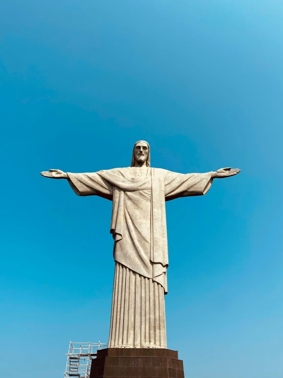 the statue is in the blue sky above a beach