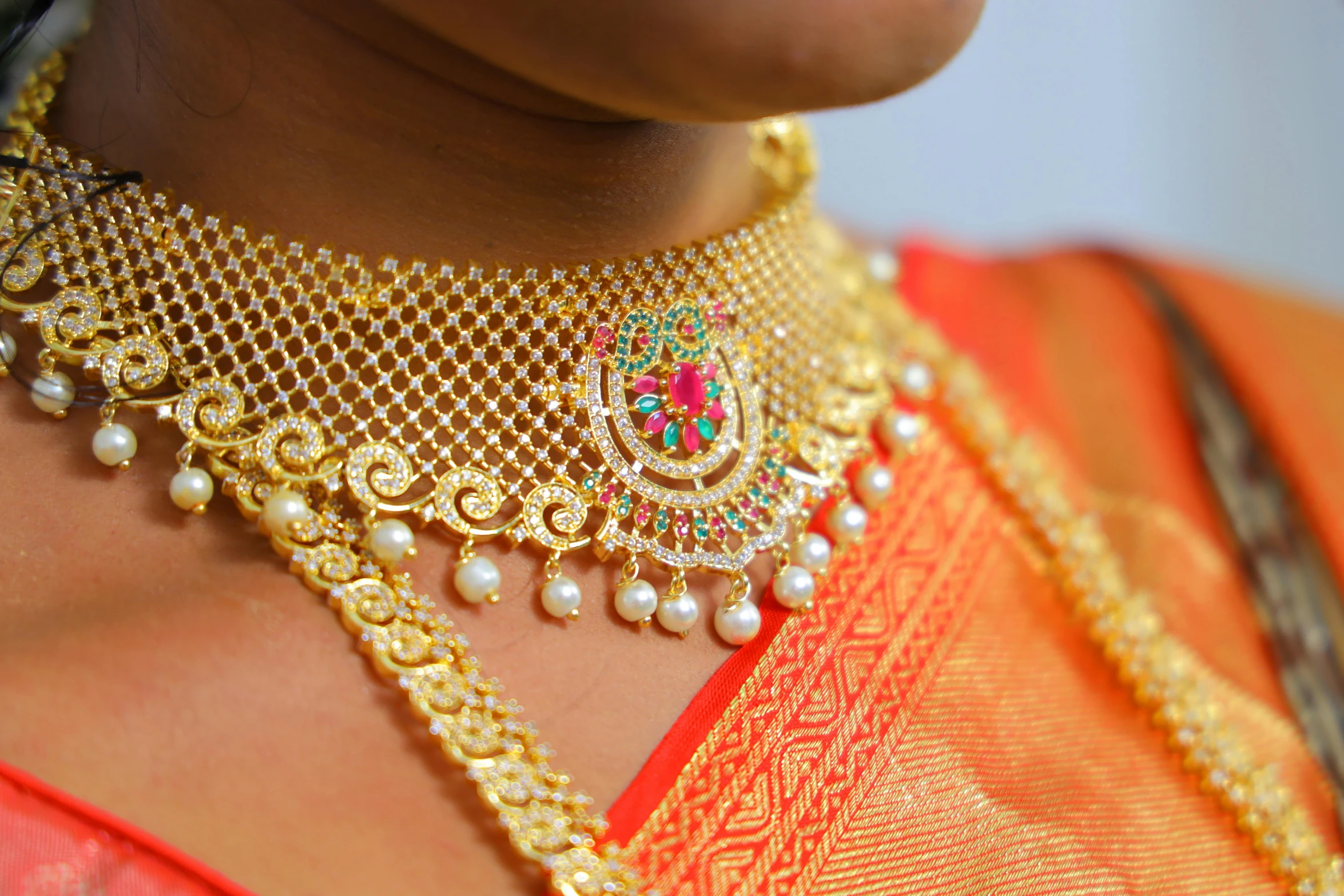 a close up of an elaborate necklace on a lady