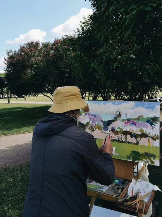 a man is using his brush to paint a landscape