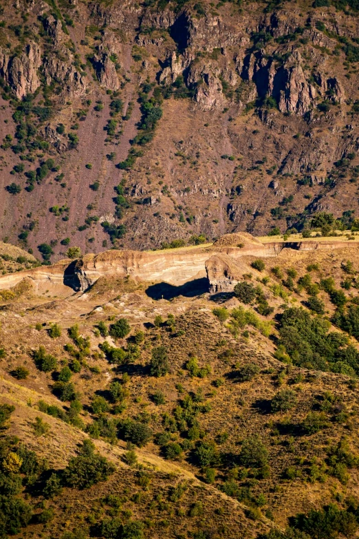 a large mountainside with a mountain in the distance