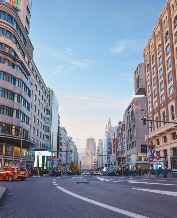 a wide street with several buildings and cars on it