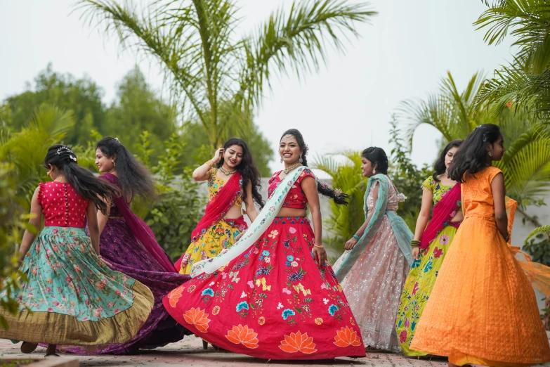 the girls in colorful clothes are walking on a cobblestone