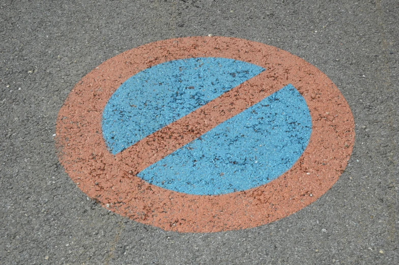 a blue and orange sign sitting on top of the street