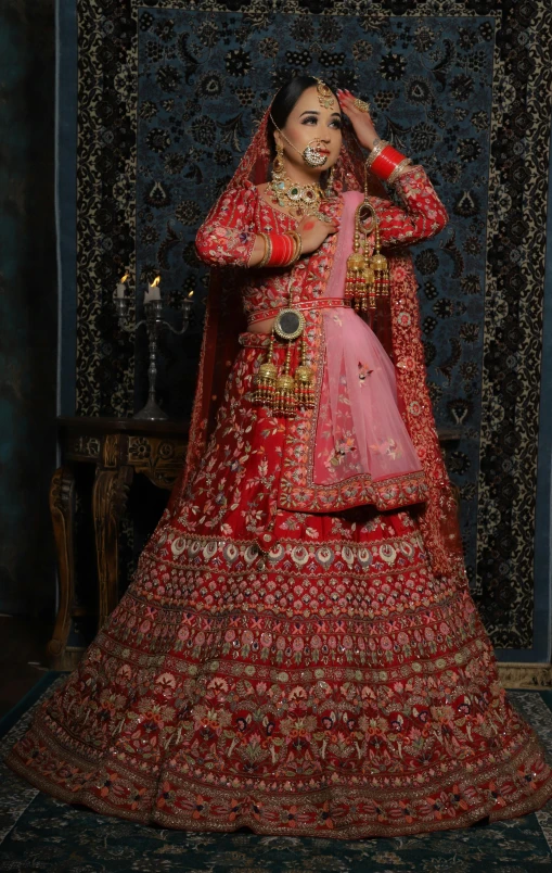 the woman is dressed in red and is wearing a traditional indian wedding outfit