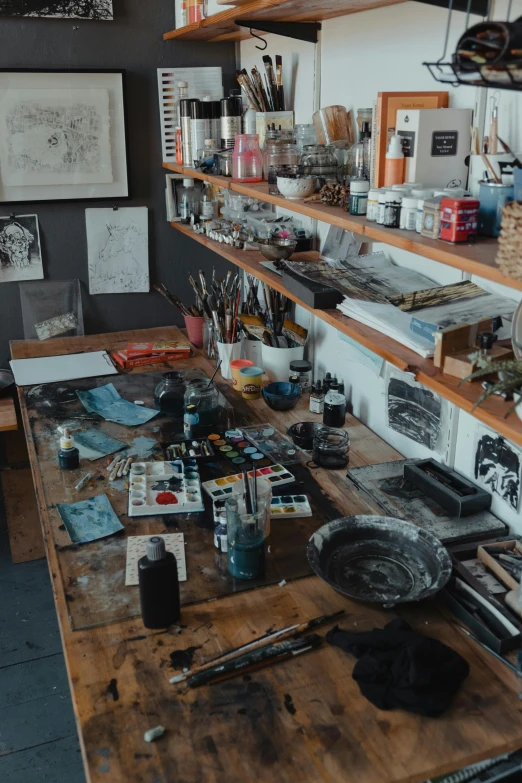 a wooden table with an open shelf filled with paint