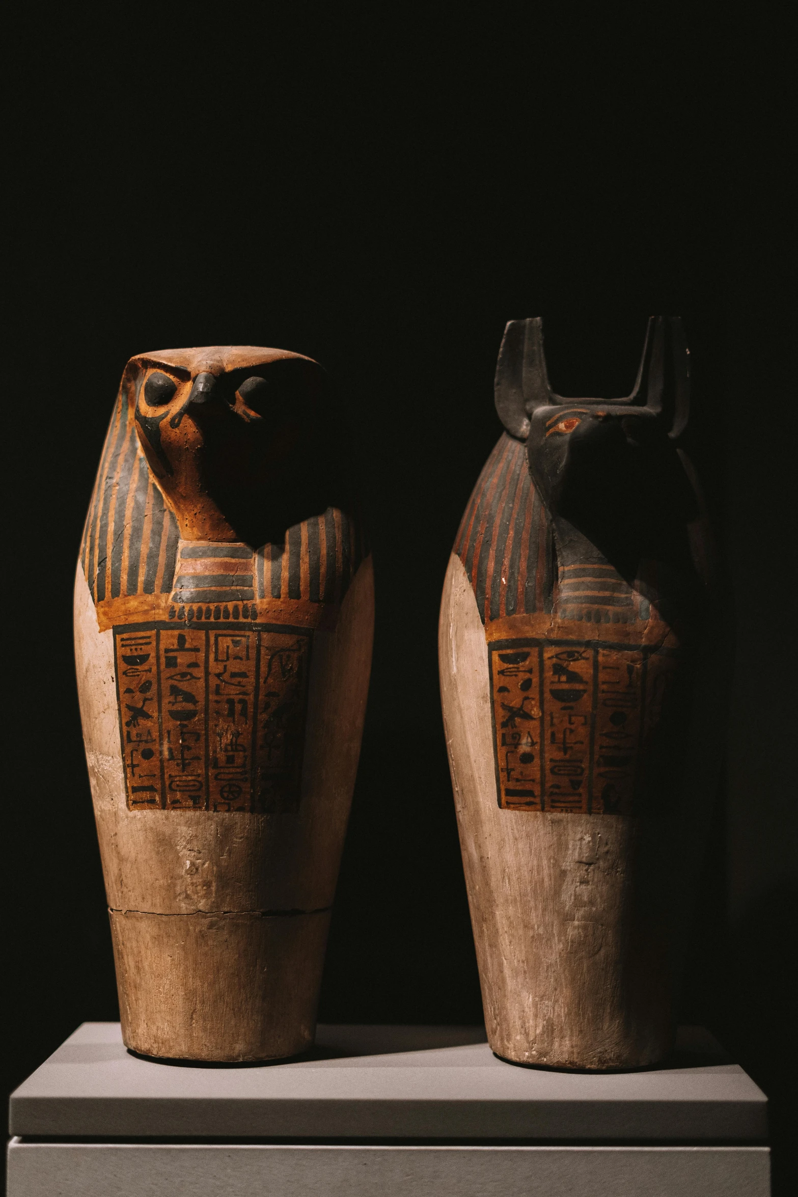 two brown vases with designs sit on top of a table