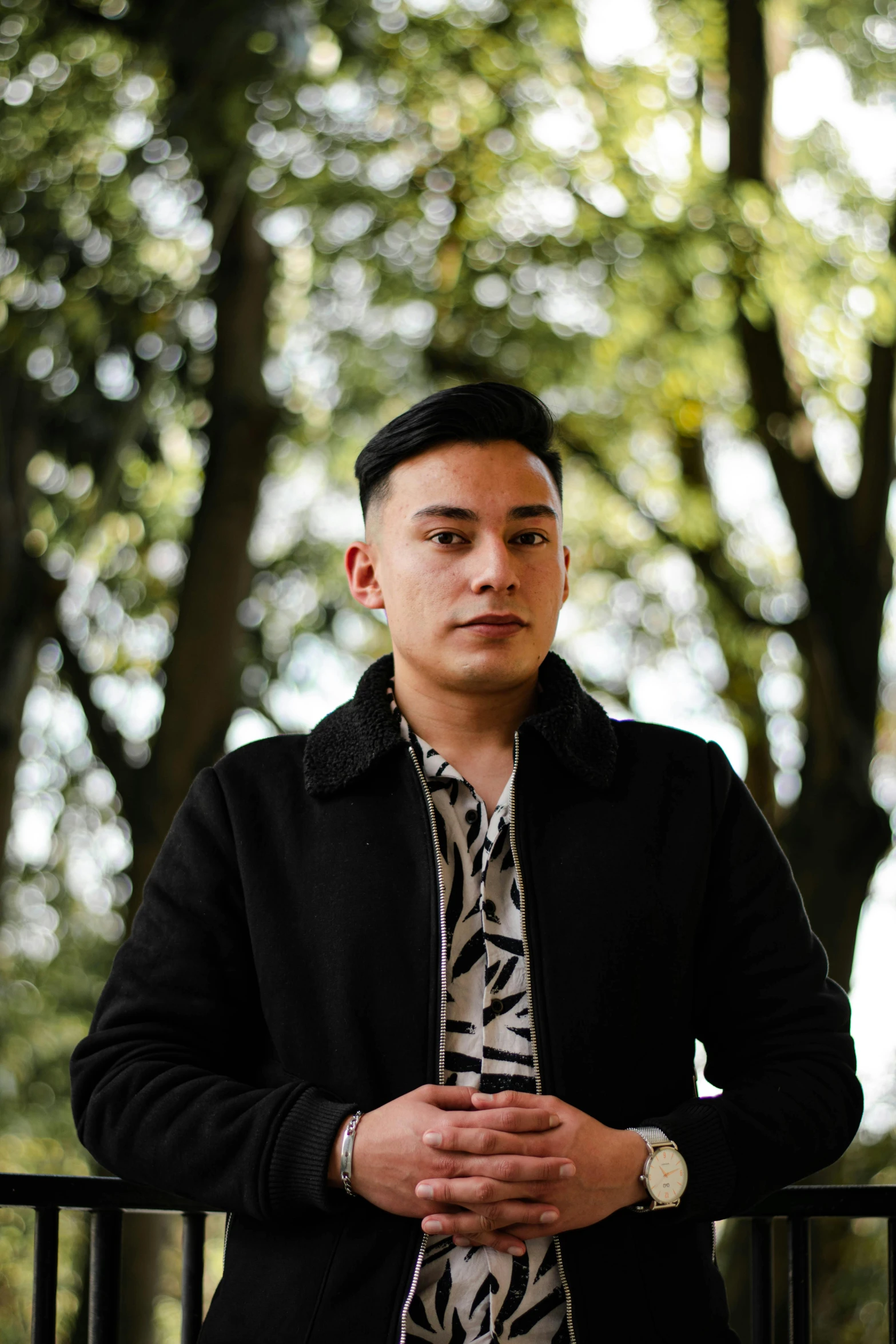 an asian man wearing a black jacket and tie