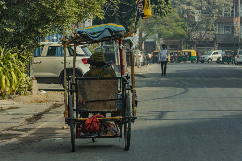 a cart loaded with various items sits on the side of a road