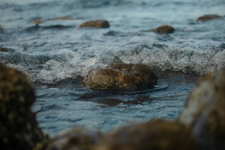 the water is swirling as it passes over rocks