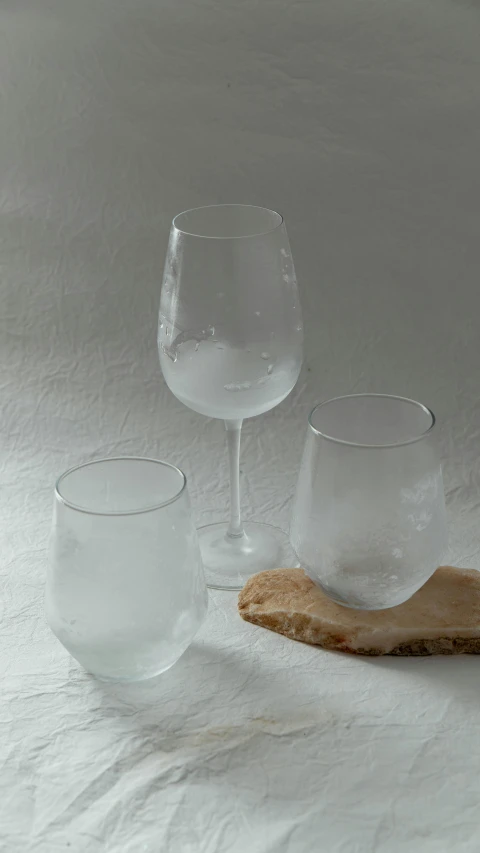wine glasses sitting on top of a wooden board
