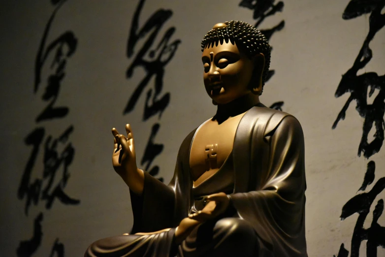 buddha statue in front of wall with words and writing on it