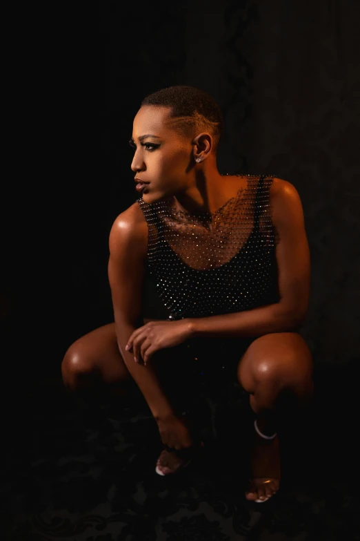 a woman in a black dress is sitting on the ground