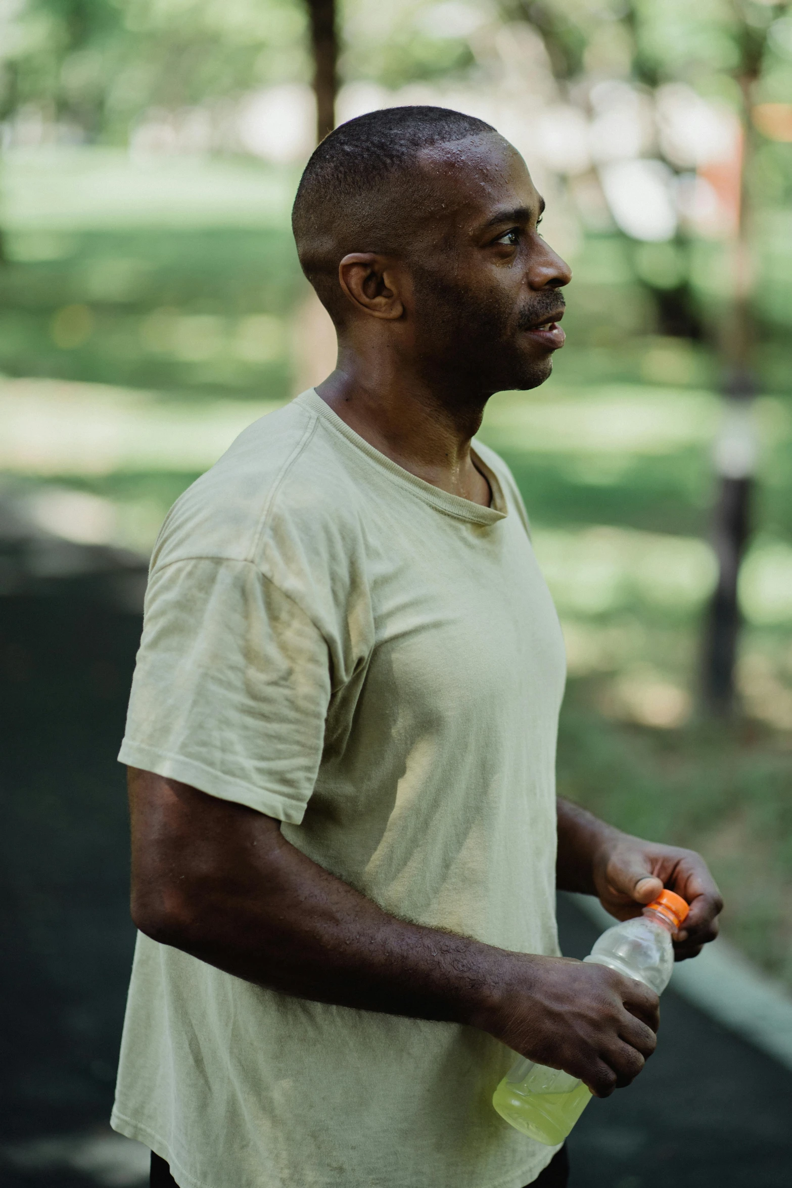 a man holding onto a bottle in the park