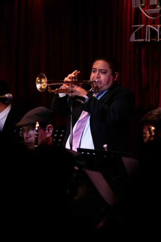 a man is playing the trumpet in front of other people