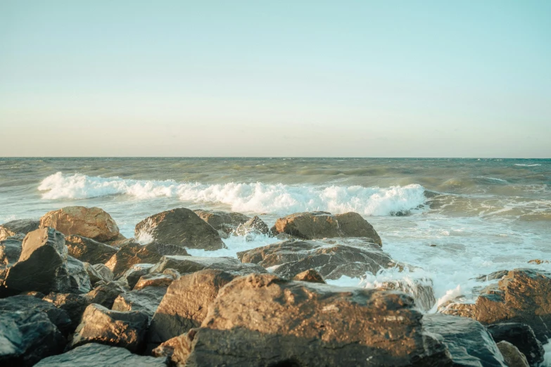 rocks that are next to the water on the shore