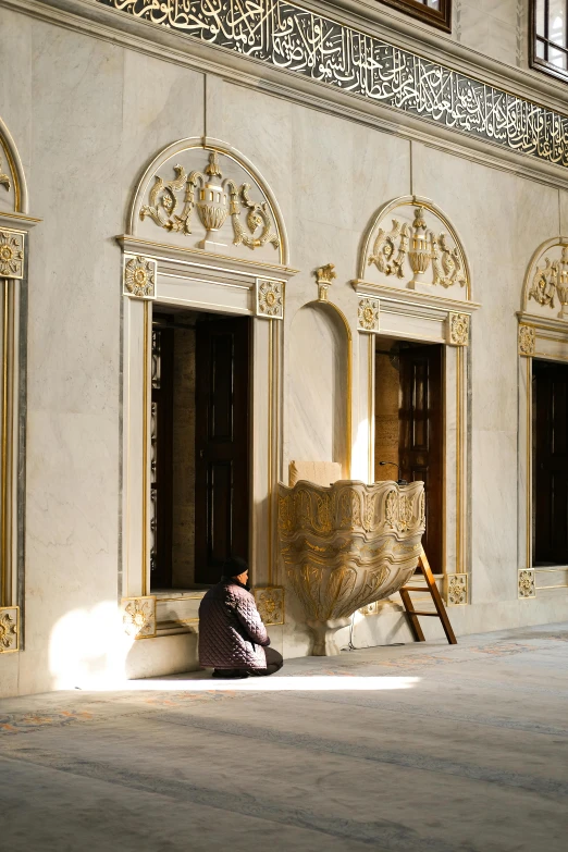 a person sitting in a chair under the shade on the sidewalk