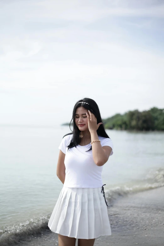 girl posing on beach by ocean in dress