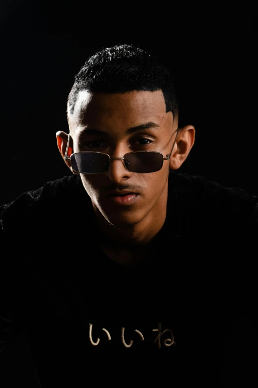 a man wearing sunglasses, with dark background