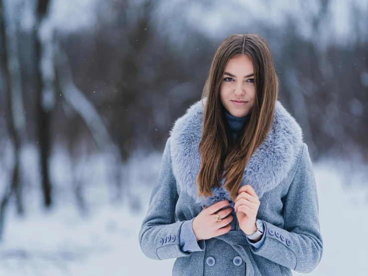 a woman is in the snow holding onto her scarf