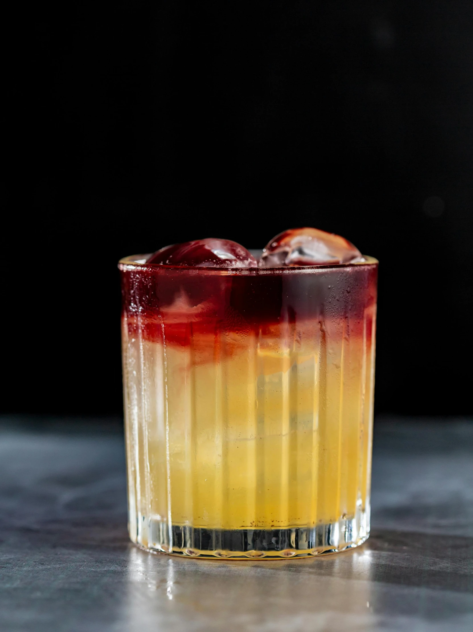 an orange and yellow drink in a glass on a table