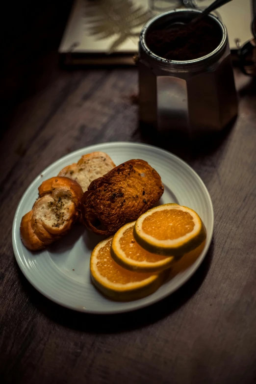 a plate full of bread and oranges sits on a table