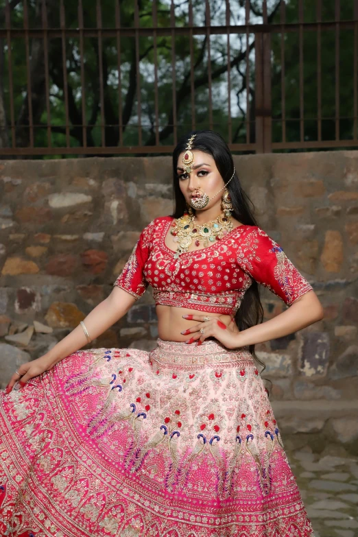 an indian girl in a red lehenga poses for the camera