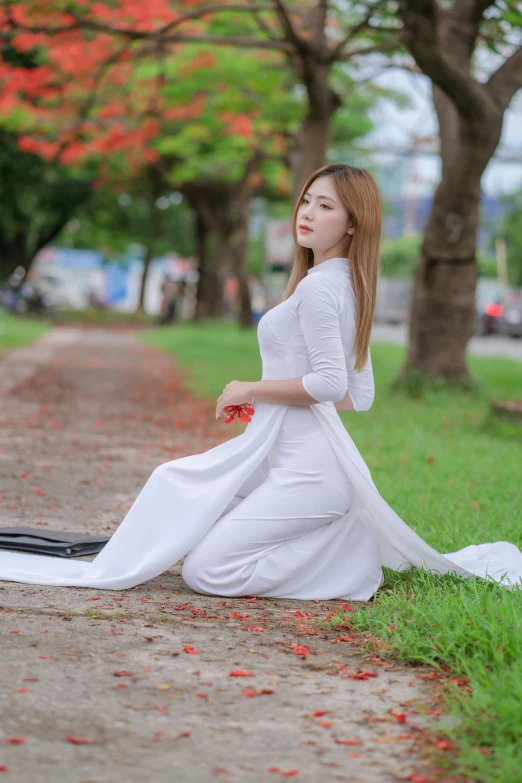 a girl with long hair is sitting on the ground