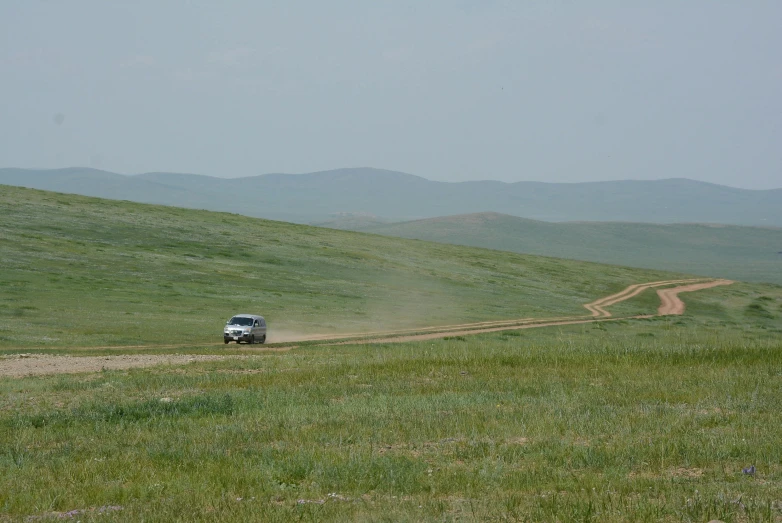 a truck riding down the road with a long dirt road