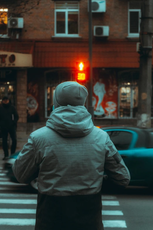 woman walking down street looking at the traffic light