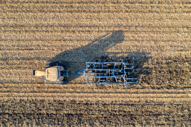 a plow in a field casts a long shadow