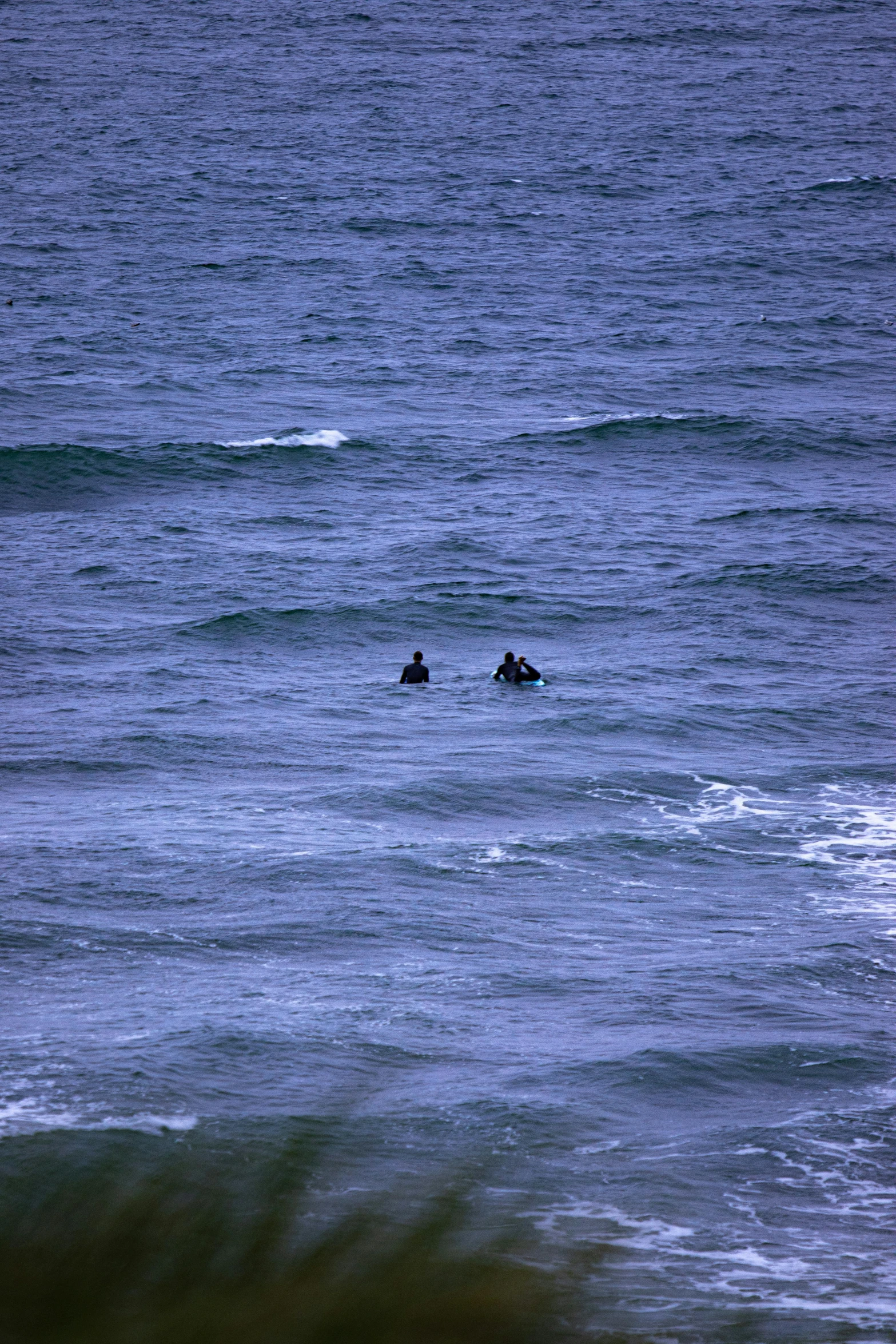 a couple of people riding surfboards on top of the ocean